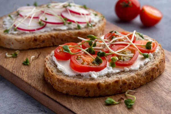 Крупный план бутерброда с овощами, микрозеленью и зерновым хлебом на сером фоне — стоковое фото