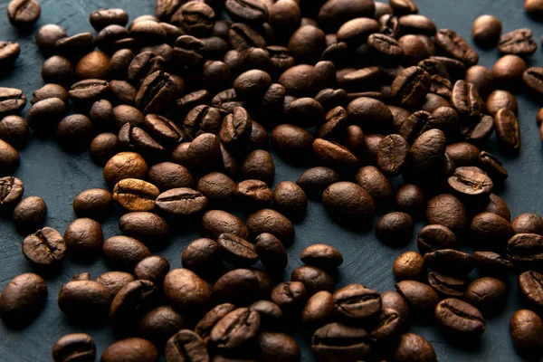 A lot of coffee beans on a blue background. Selective focus