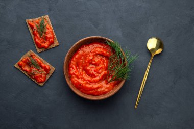 Koyu arkaplanda bir kasede pişmiş biber aperatifi.