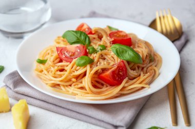 Domatesli makarna ve arka planda fesleğen. Yakın çekim, seçici odaklanma.