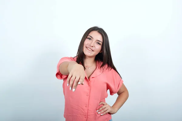Vrouw op roze achtergrond wijst vinger naar u met een zelfverzekerde uitdrukking — Stockfoto