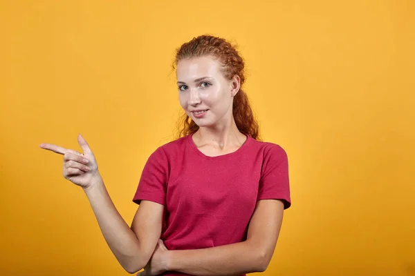 Preciosa mujer europea apuntando hacia el lado derecho con su dedo índice —  Fotos de Stock