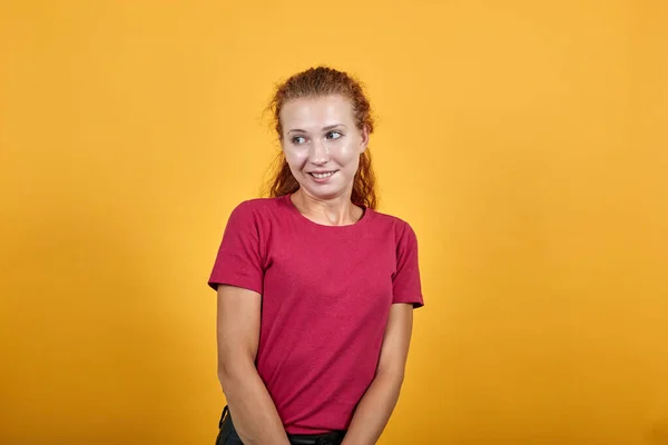 Joven mujer europea de pie sobre una pared aislada con expresión de cara confusa . —  Fotos de Stock