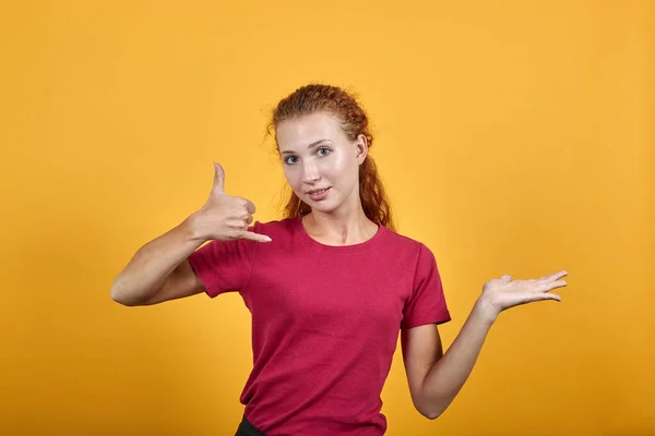 Joven europea con la ayuda de su mano derecha mostrando el gesto del teléfono . —  Fotos de Stock