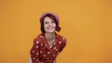 Gülümseyen ve zafer işareti gösteren güzel, komik bir kadın.
