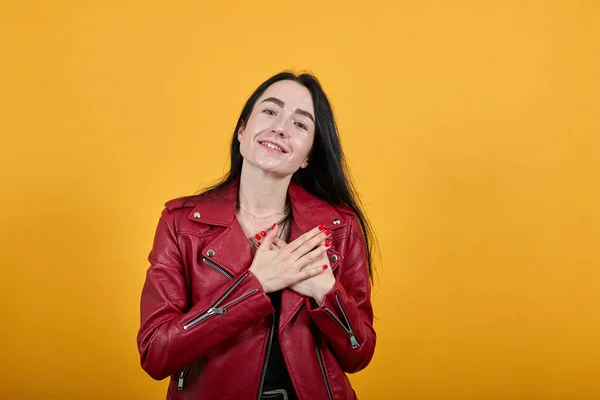 Porträtt av leende trevlig ung kvinna hålla händer på bröst, hjärta — Stockfoto