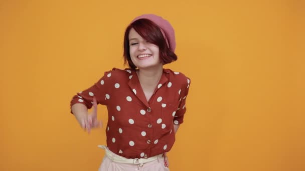 Chica bonita vistiendo bonito sombrero rosa sobre la pared en el estudio sonriendo, mirando tan divertido — Vídeo de stock