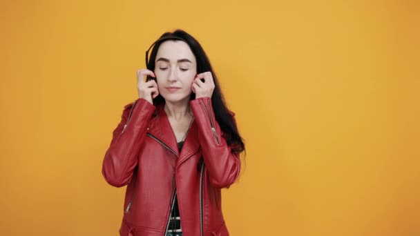 Mooie glimlachende jonge vrouw met gesloten ogen, luister naar muziek met koptelefoon. — Stockvideo