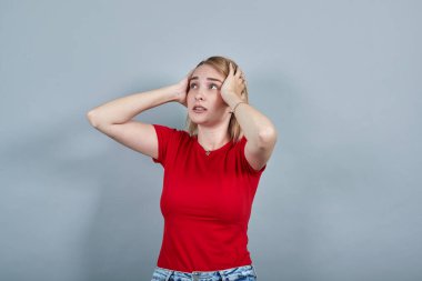 Şok olmuş genç bir kadının portresi yan yana bakıyor, el ele tutuşuyor.