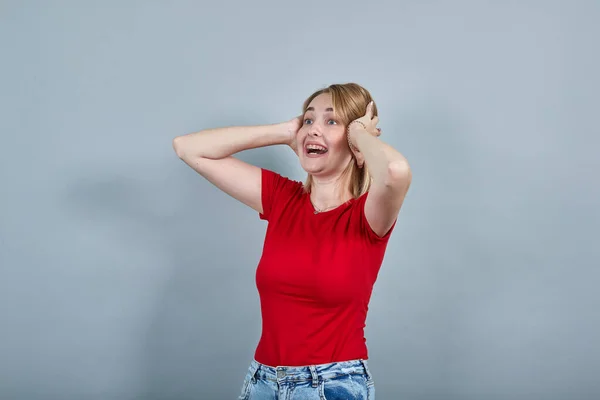 Křičící mladá dáma v neformálním oblečení vzhlížející a zvedající ruce za hlavu — Stock fotografie