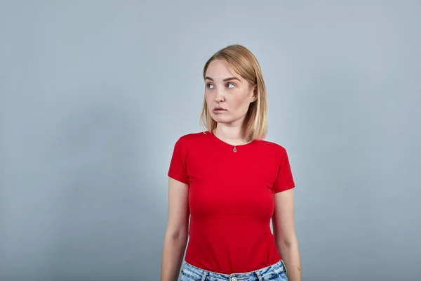 Retrato de senhora preocupada olhando para o lado, mordendo lábios isolados na parede cinza brilhante — Fotografia de Stock