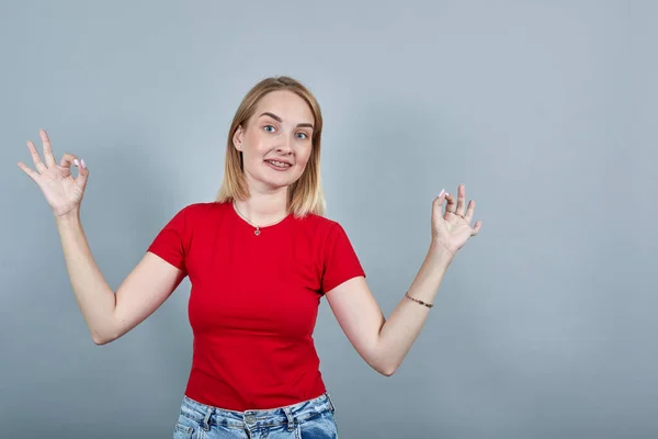 Γελώντας αστεία νεαρή γυναίκα με κόκκινο πουκάμισο κρατήστε τα χέρια σε χειρονομία γιόγκα, χαλάρωση — Φωτογραφία Αρχείου
