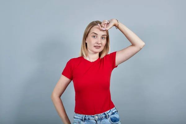 Όμορφη γυναίκα με κόκκινο πουκάμισο, με κάμερα, να βάζει χέρι στο κεφάλι. — Φωτογραφία Αρχείου