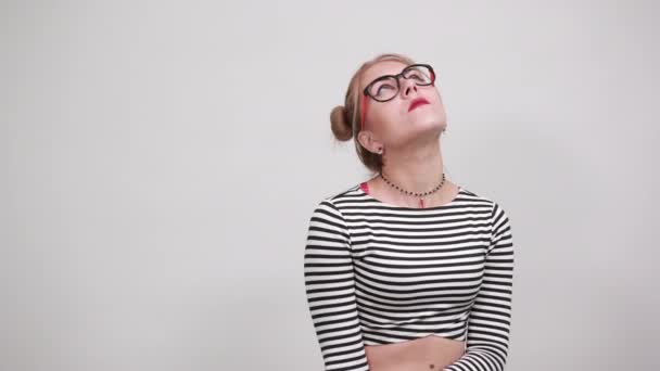 Teenager girl wearing striped shirt looking up, keeping fingers near head — Stock Video