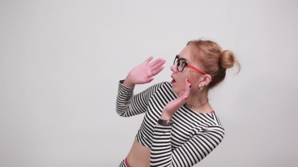 Jovem caucasiano atraente mulher mantendo as mãos no rosto, olhando chocado — Vídeo de Stock