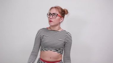 Şok olmuş genç bir kadın, günlük giysiler içinde çığlık atıyor, avuçlarını gösteriyor.