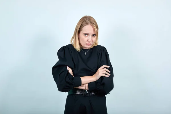 Jovem mulher de vestido preto, cachecol de mãos cruzadas isolado na parede branca — Fotografia de Stock