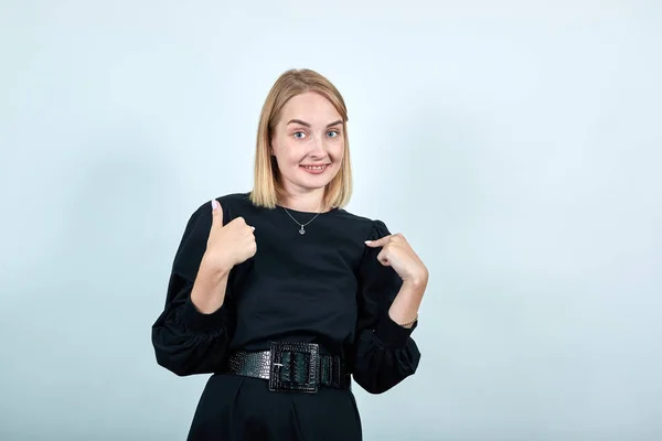Vacker ung kvinna i svart klänning pekar pekfingrar på sig själv — Stockfoto