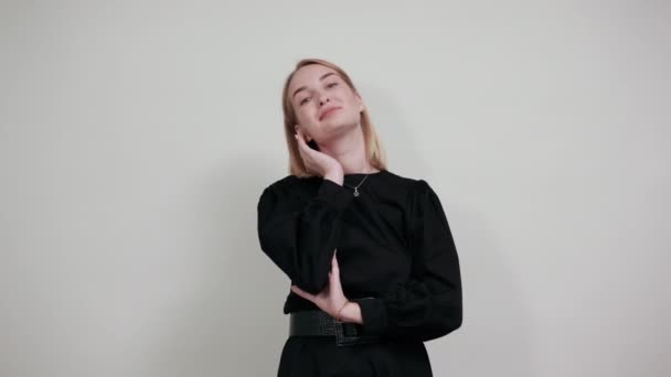 Портрет милой молодой женщины в черном платье с подбородком на руках — стоковое видео