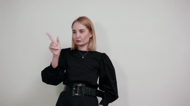 Side view of young girl in black casual shirt pointing index fingers on camera — Stock Video