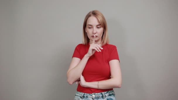 Frau hält Mund auf, legt Hand auf den Kopf, zeigt Zeigefinger zur Seite — Stockvideo