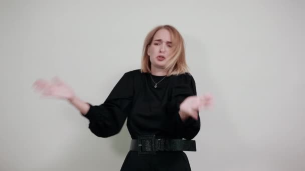 Retrato de jovem mulher em camisa casual escuro olhando câmera, estendendo a mão — Vídeo de Stock