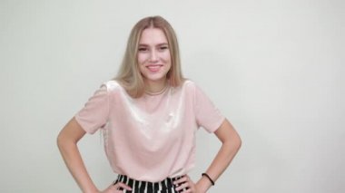 Neşeli genç bir kadının portresi günlük giysiler içinde yukarı bakıyor, ellerini kaldırıyor.