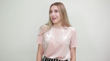 Beyaz tenli çekici kız omuzlarını kaldırırken önemsiz bir jest yapıyor.