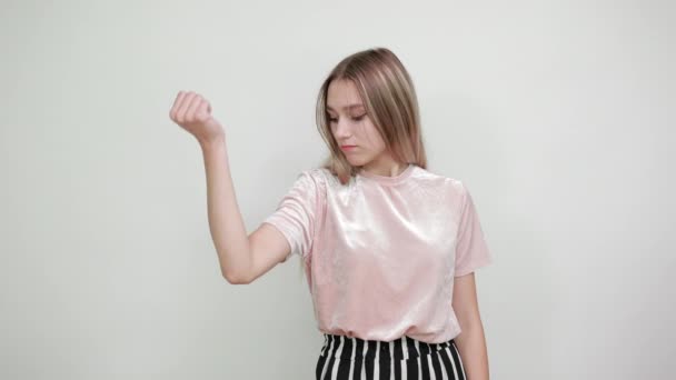 Mulher atraente vestindo camisa bonita olhando nas mãos, tentando seus músculos — Vídeo de Stock