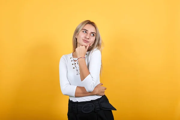 Joven mujer bonita mirando directamente, abrió los ojos con la mano en la barbilla —  Fotos de Stock