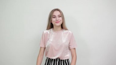 Genç, güzel, beyaz bir kadın, tamam işareti gösteriyor.