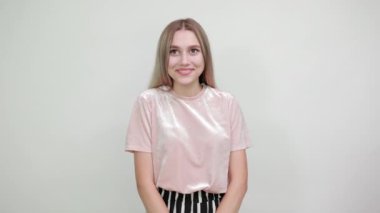 Bayan çok mutlu ve heyecanlı. Kazanan hareketi yapıyor. Kolunu kaldırıp gülümsüyor.