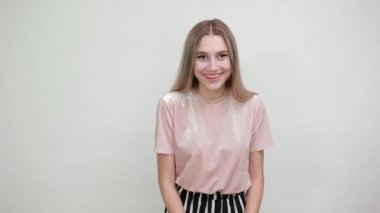 Sıradan giysiler içinde mutlu genç bir kadının portresi, avuçlarını gösteren eller.