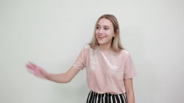 Çekici stil sahibi genç bir kadın selamlamak için elini uzatmış bekliyor.