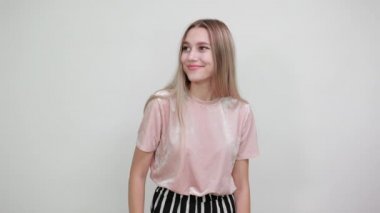 Ciddi bir genç kadın portresi. Günlük giysiler içinde. Durma hareketini avuç içi ile gösteriyor.