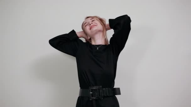 Mosolygó magabiztos gyönyörű fiatal nő pózol elszigetelt fehér fal — Stock videók