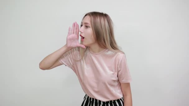 Attractive woman shouting and announcing something, keeping hand on cheek — ストック動画