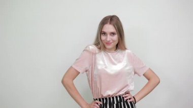 Genç ve güzel bir kadın başparmağını kaldırıyor, doğrudan kameraya bakıyor.