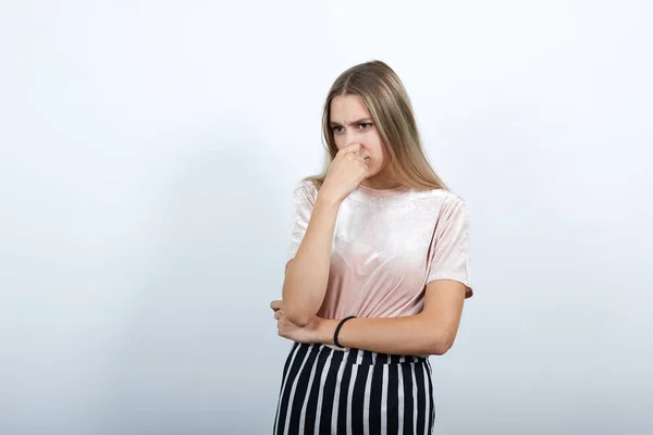 Ritratto di giovane donna confusa che guarda da parte e copre il naso con la mano — Foto Stock