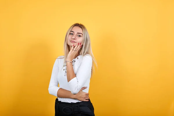 年轻漂亮的女人直视着，睁开眼睛，手放在脸颊上 — 图库照片