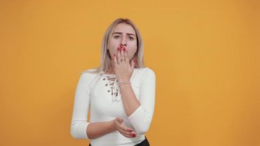 Gömlek giyen güzel kız korkmuş ve şok olmuş, elleri esneyerek ağzını kapatıyor.