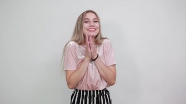 Güzel sarışın kadın ellerini yanaklarından ayırmıyor, çok mutlu görünüyor.