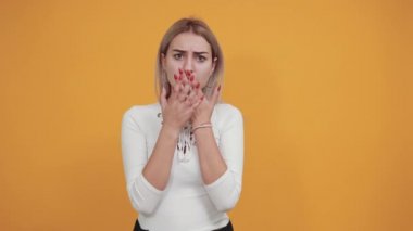 Esmer kız şok olmuş görünüyor, elleri ağızda, gömlekle dolaşmaktan sıkılmış.