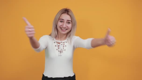 Csinos lány ünnepli a győzelmet a győztes pozícióban, tartja hüvelykujját felfelé — Stock videók