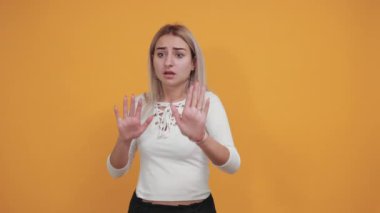 Korkmuş genç bir kadının portresi, avuçlarını kaldırıyor, jesti durdurun.