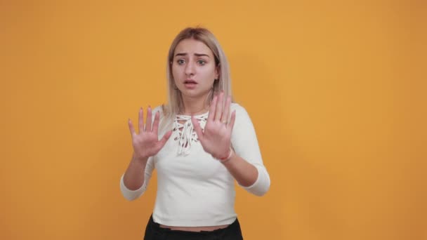 Портрет страшної шокованої молодої жінки, що піднімається руками, показує долоні, зупиняє жест — стокове відео