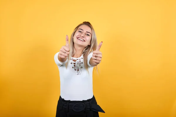 Atractiva chica joven caucásica mantener los puños directamente, ojos cerrados, sonriendo — Foto de Stock