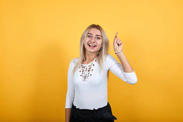 Retrato de una joven alegre con ropa bonita levantando el dedo, como ganador —  Fotos de Stock