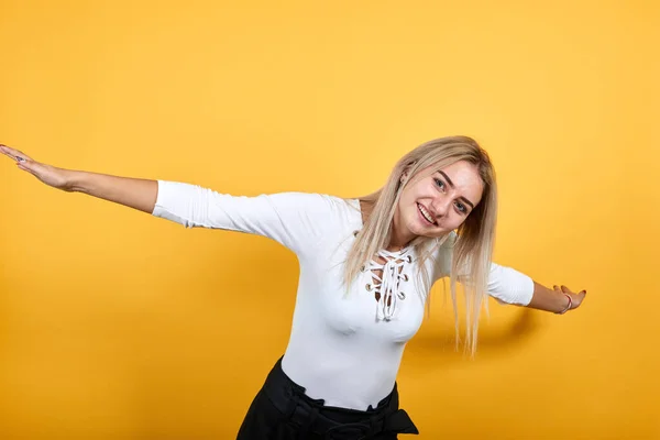 Rire jeune femme en vêtements décontractés, debout et écartant les mains — Photo