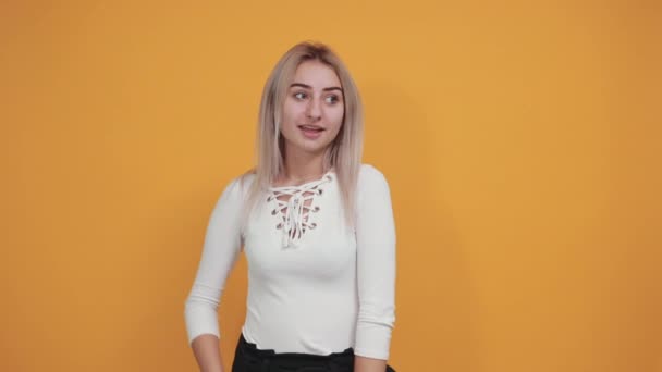Pretty young caucasian woman keeping hand up, showing space for advertising — Stock Video
